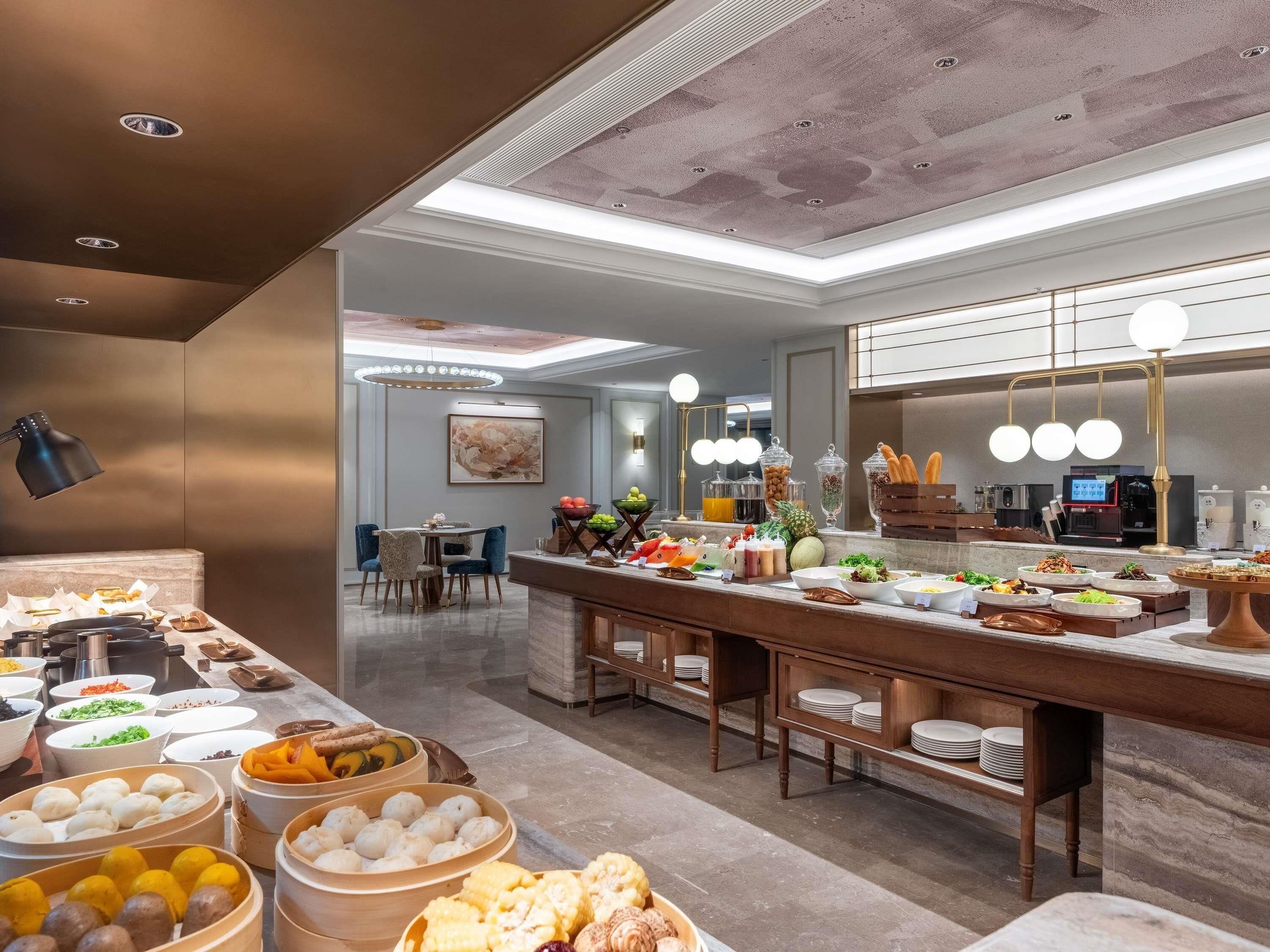 A buffet area with various food options, a seating area with chairs, and a modern ceiling design.
