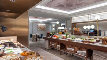 A buffet area with various food options, a seating area with chairs, and a modern ceiling design.
