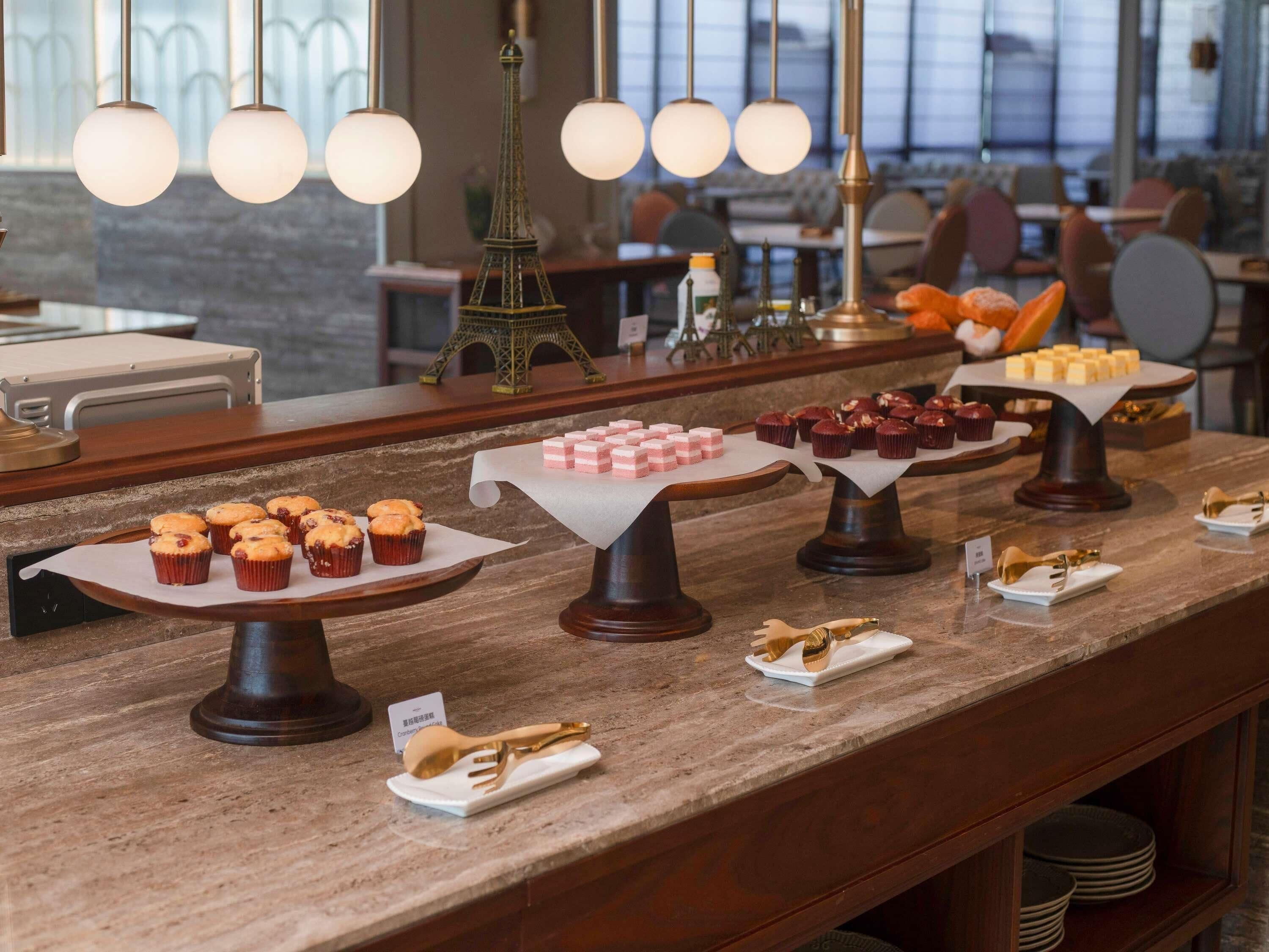 A buffet setup with various food items and a decorative Eiffel Tower model.