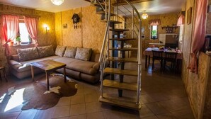 A cozy living room with a sofa, a coffee table, and a staircase leading to a kitchen area.