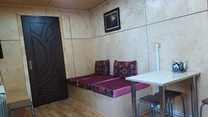 A compact room with a bed, a table, and two chairs.