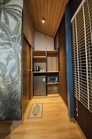 Cozinha compacta com geladeira, micro-ondas e chaleira.