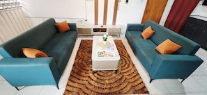 A living room with two sofas, a coffee table, and a patterned rug. -  1-BR Bright & Quite Apartment & Large Living Room (Accra)