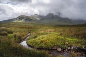 A natural landscape with a stream, grassy fields, and mountains in the background. - TEST PROPERTY - Affiliate Testing (Seattle)