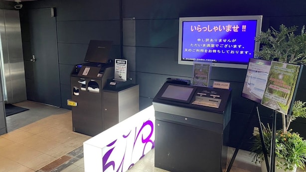 A reception area with a digital display, a reception desk, and a signboard. - HOTEL PALETTE GOLD (Kurashiki)