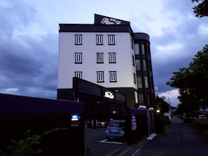 A hotel with a modern facade, multiple windows, and a sign indicating it is a hotel.