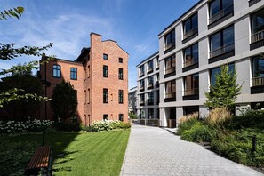 A modern building with a brick facade and a flat-roofed structure with balconies.