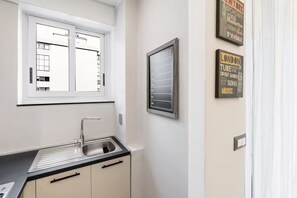 Eine Küche mit Fenster, Spüle und einem an der Wand befestigten Kalender.