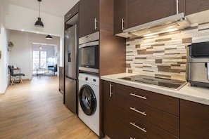 A modern kitchen with built-in appliances, wooden cabinetry, and a stone backsplash. - Athens Urban Haven Exarchia (Athina)