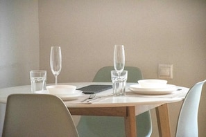 A dining table with four chairs, a set of cutlery, and two wine glasses. - Athens Urban Haven Exarchia (Athina)