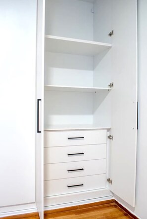 Une armoire blanche avec de nombreux tiroirs et des étagères.