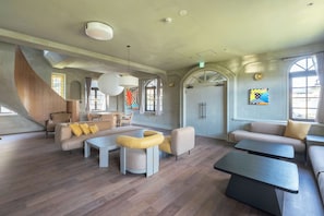 Amplia sala de estar con diseño moderno, que incluye un sofá grande, una mesa de centro y una zona de estar con una mesita.