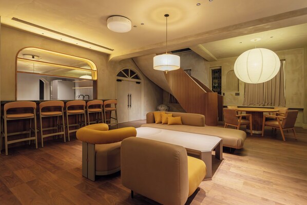 Un interior moderno con zona de comedor, sofá y escalera.