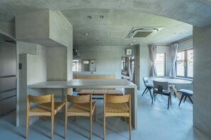 Una cocina moderna con una isla central, sillas de madera y una mesa de comedor.