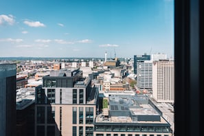 Eine Stadtansicht mit verschiedenen Gebäuden, darunter moderne und ältere Architektur, unter einem klaren Himmel.