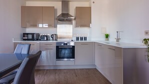 Uma cozinha moderna com forno embutido, micro-ondas e máquina de café.
