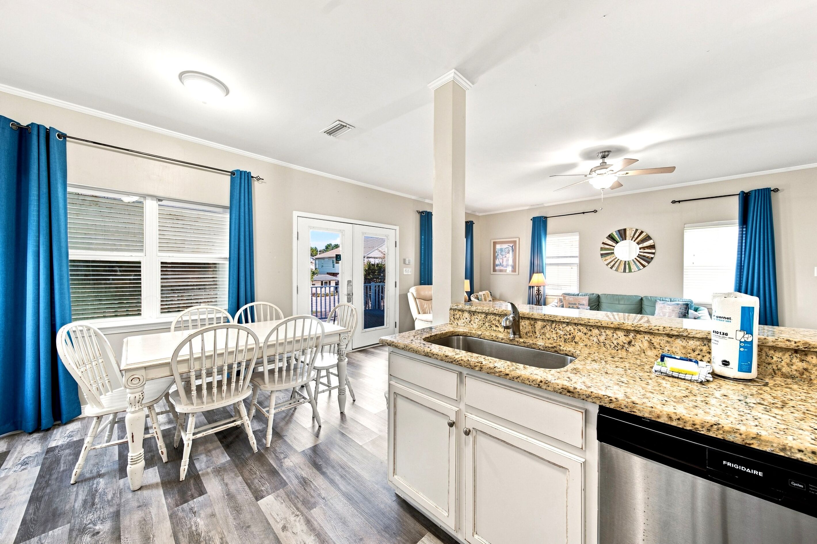 A modern kitchen with a granite countertop, stainless steel sink, and a dishwasher.