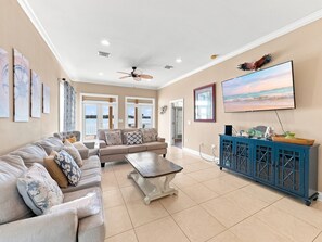 A spacious living room with a grey sofa, a coffee table, and a blue cabinet. - Eagles Nest | Sleeps 10 | Bay Views Pet-Friendly (Gulf Shores)