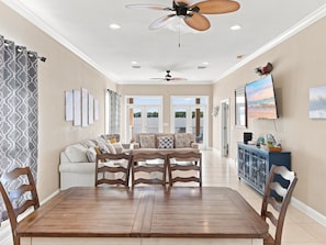 A spacious living area with a wooden dining table, two sofas, and a ceiling fan. - Eagles Nest | Sleeps 10 | Bay Views Pet-Friendly (Gulf Shores)