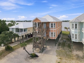 A waterfront property with multiple buildings, including a central structure with a staircase and a smaller building with a balcony. - Eagles Nest | Sleeps 10 | Bay Views Pet-Friendly (Gulf Shores)