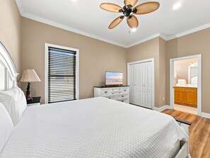 A bedroom with a bed, a television, a wardrobe, and a ceiling fan. - Eagles Nest | Sleeps 10 | Bay Views Pet-Friendly (Gulf Shores)
