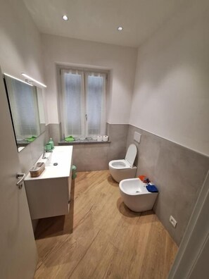 A compact bathroom with a toilet, bidet, and a small sink area. - da sandra (Isola del Cantone)
