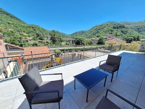 A terrace with outdoor furniture and a view of a mountainous landscape. - da sandra (Isola del Cantone)