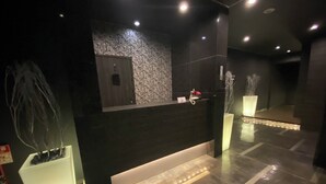 A reception desk with a dark counter, a patterned wall, and a modern design.