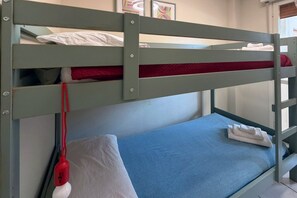 A bunk bed with a blue mattress and a red headboard. - A cozy and comfortable 49 square meters apartment, perfect for five people, located on the first floor of a building with an elevator (NOT accessible to people with disabilities).The property is situated within the Anna Maria residential complex in Lid (Lido Adriano)