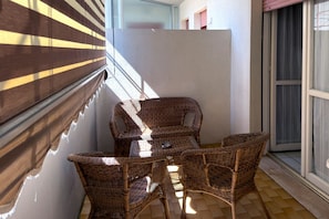 A balcony with wicker furniture, a glass door, and a view of the outside. - A cozy and comfortable 49 square meters apartment, perfect for five people, located on the first floor of a building with an elevator (NOT accessible to people with disabilities).The property is situated within the Anna Maria residential complex in Lid (Lido Adriano)