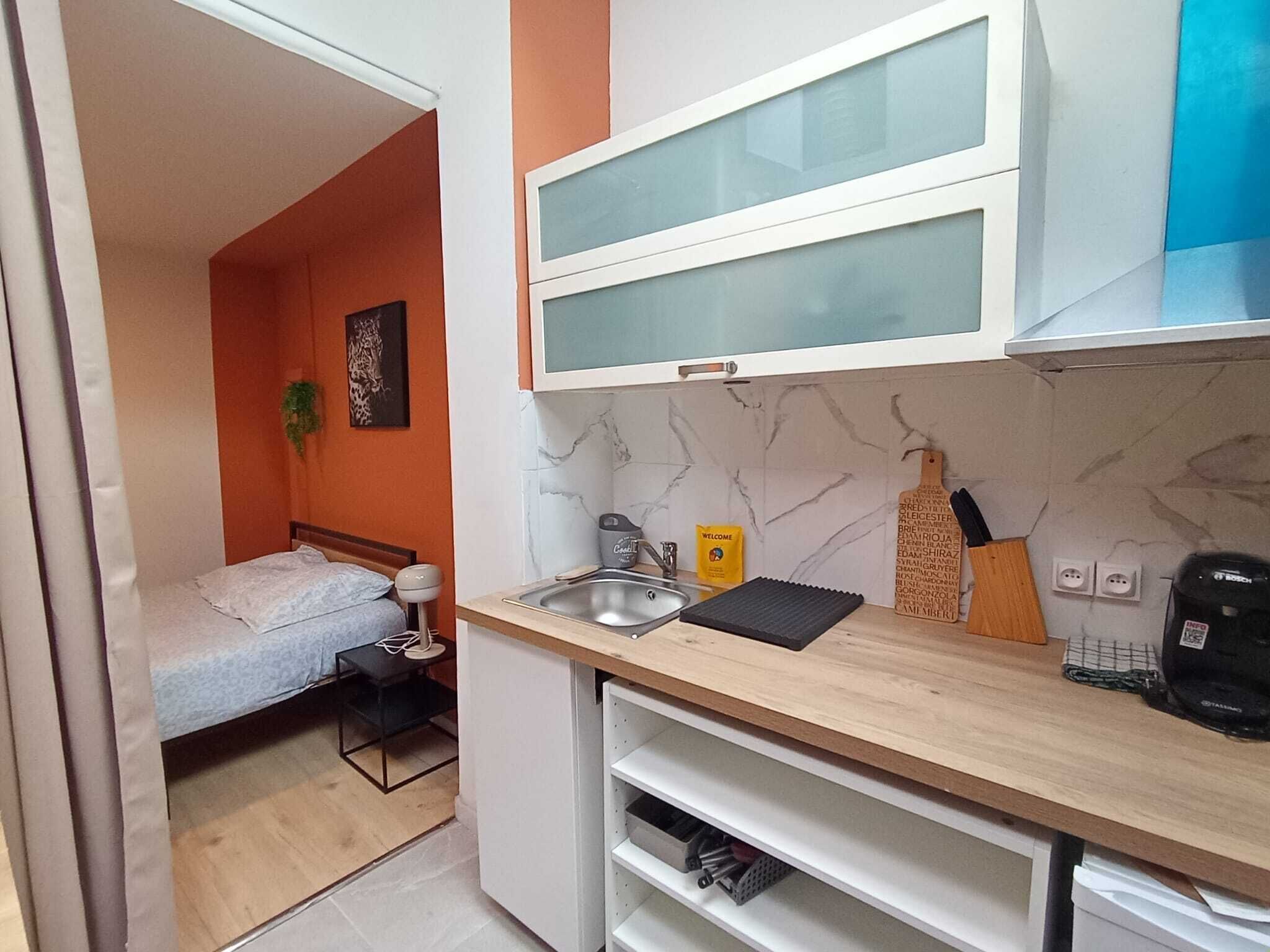 A compact kitchen with a sink, a coffee maker, and a small countertop.