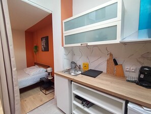 A compact kitchen with a sink, a coffee maker, and a small countertop.