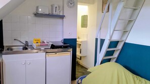 A compact kitchenette with a sink, a toaster, a kettle, and a coffee maker. There is a clock on the wall and a ladder leaning against the wall. - Bail mobilité Solo'Room, bollaert, fac, 1 pers (Lens)