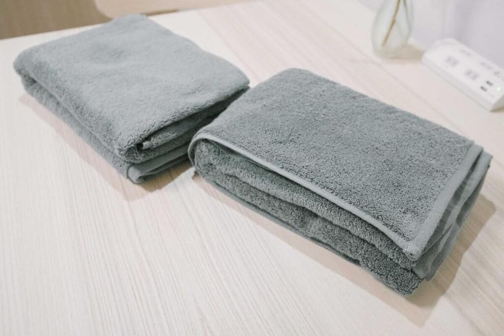 A stack of folded towels on a wooden surface.