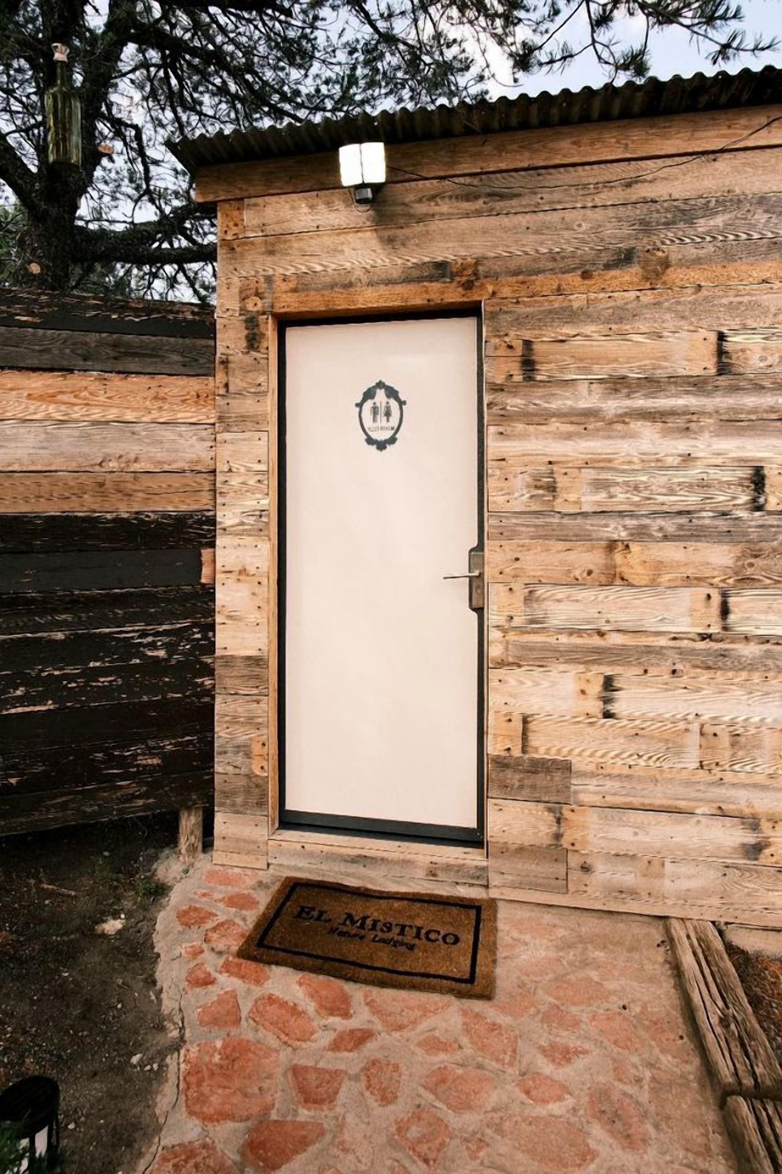 A wooden door with a metal handle and a small emblem above it.