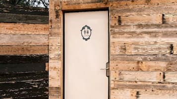 A wooden door with a metal handle and a small emblem above it.
