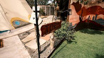 A sign labeled 'TORO' in a courtyard with artificial grass, a mural, and a water feature.