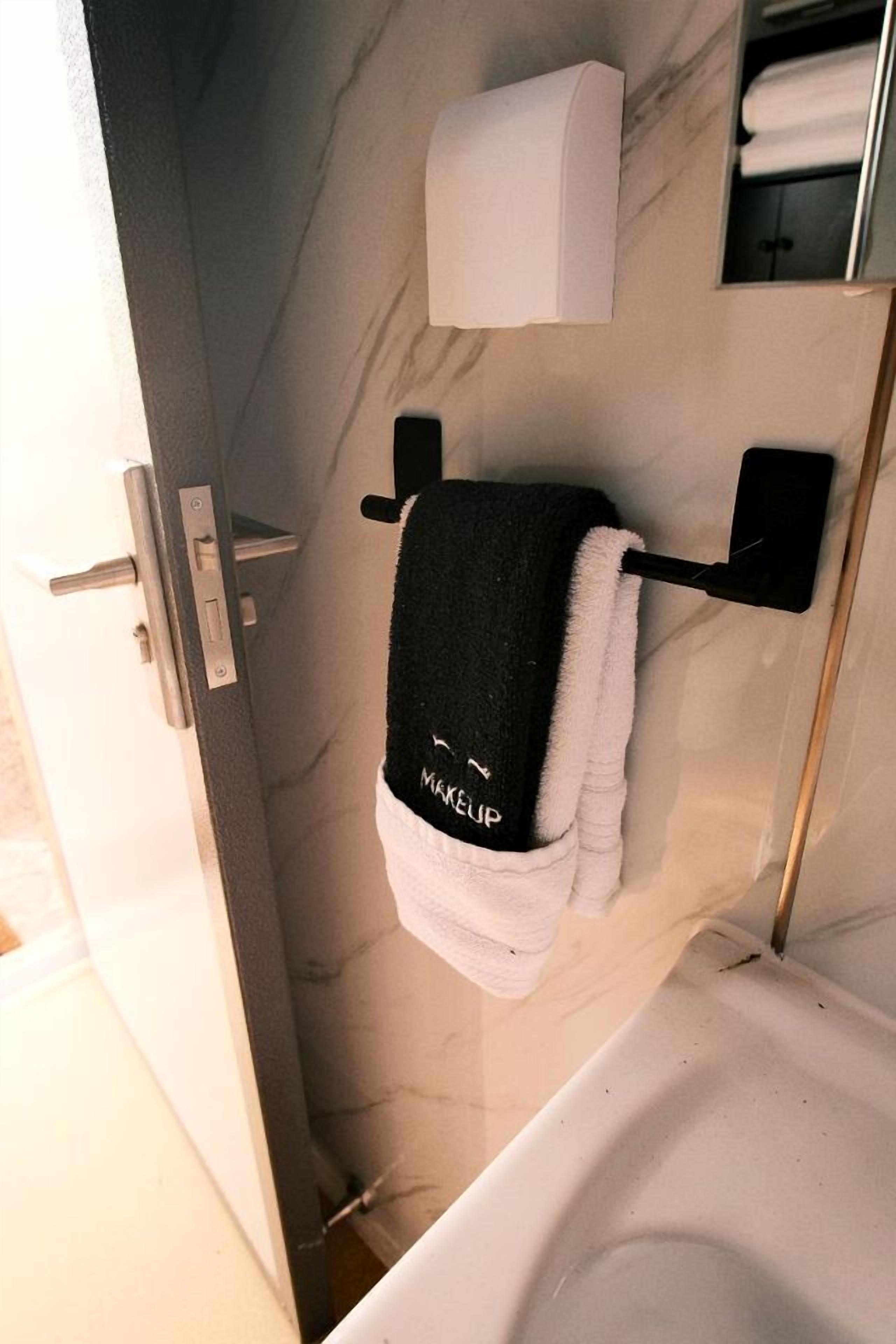 Ein Badezimmer mit Handtuchhalter, Toilettenpapierhalter und Spiegel.