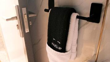 Ein Badezimmer mit Handtuchhalter, Toilettenpapierhalter und Spiegel.