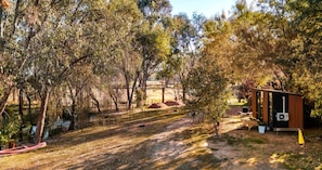 A campsite with a small wooden structure, a canoe, and a tent.