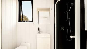 A bathroom with a toilet, sink, and shower.