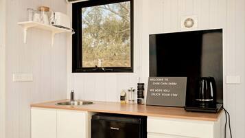 A kitchen with a sink, a black coffee maker, a Hisense dishwasher, and a welcome sign.