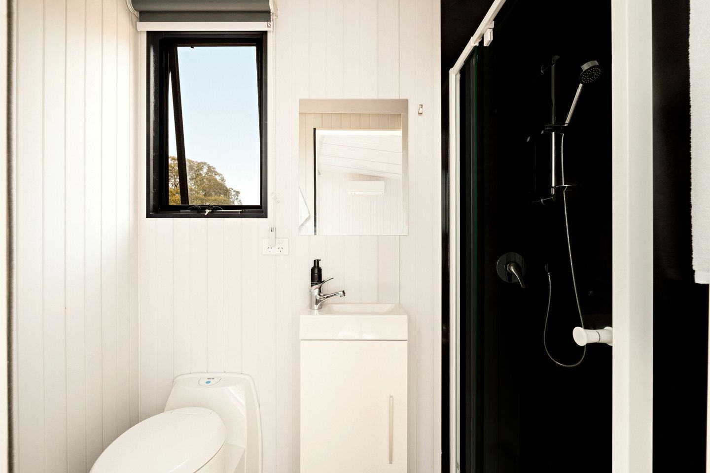 A bathroom with a toilet, sink, and shower.
