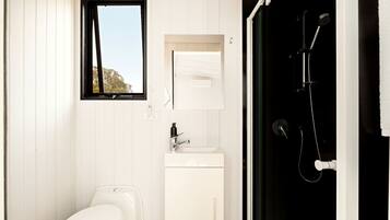 A bathroom with a toilet, sink, and shower.