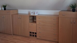A room with wooden cabinets, a red hanging light, and a small plant on the left.