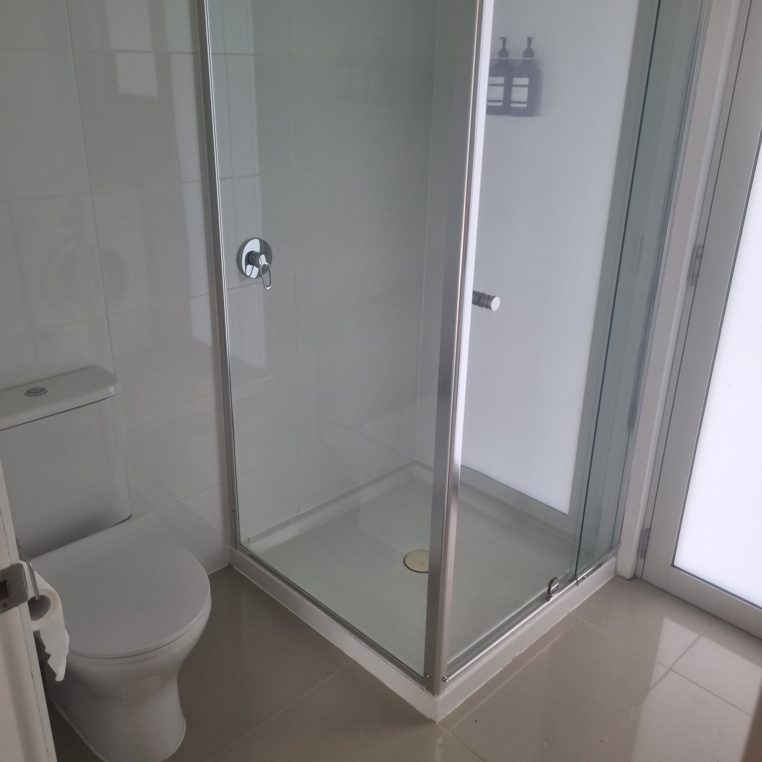 Une salle de bain moderne avec une douche à parois de verre, des toilettes et un lavabo.