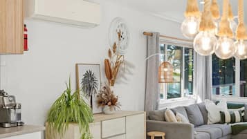 A modern living space with a kitchen, a sofa, and a dining area.