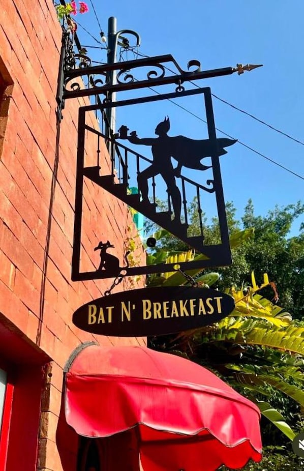 A sign for 'Bat N' Breakfast' with a silhouette of a bat and a cat.