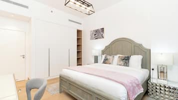 A bedroom with a bed, bedside lamps, a headboard, a wardrobe, and a zebra artwork.