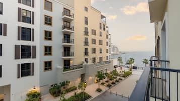 A multi-story hotel with balconies, a waterfront view, and a landscaped courtyard.